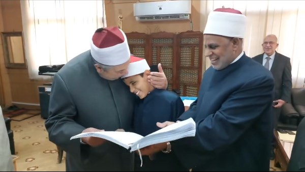 رئيس قطاع المعاهد الأزهرية يقبل رأس طالب من ذوي الهمم ويهديه مصحفًا مطبوعًا بطريقة برايل